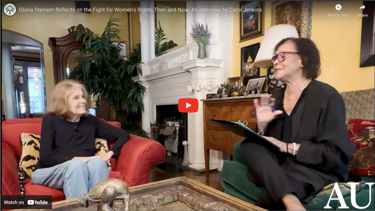 A still from the video of Gloria Steinem's Interview, showing Gloria Steinem sitting in her living room, talking to Carol Jenkins.